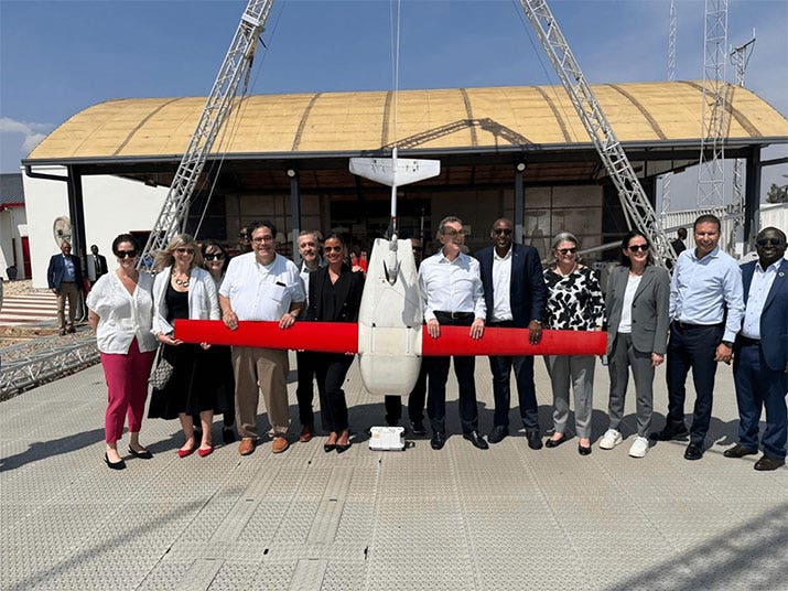 Albert Bourla and other Pfizer leaders pose beside a drone